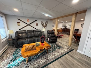 Un salon avec un canapé en cuir, une table basse en bois et un tapis à motifs.