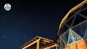 Una estructura de pérgola de madera bajo un cielo estrellado.