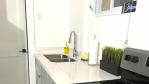 Una cucina con un lavello doppio, un fornello e un forno a microonde.
