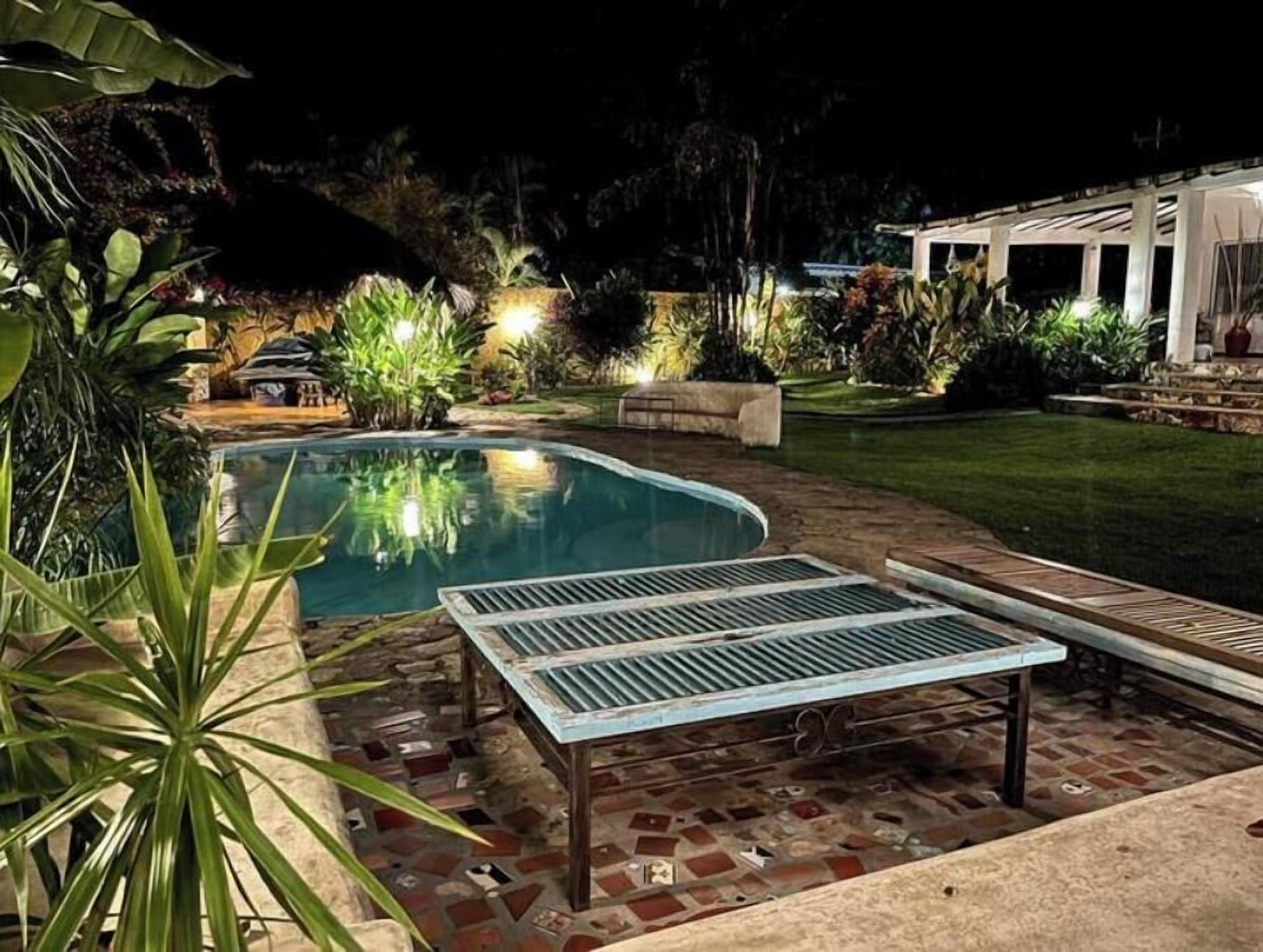 A swimming pool with a sunken seating area and a patio.