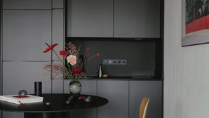 A modern kitchen with a black countertop, a vase with flowers, and a book.
