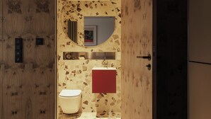 A modern bathroom with a wooden vanity, a toilet, and a mirror.