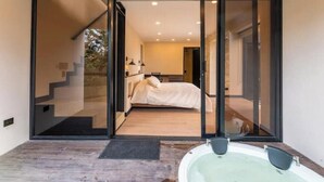 Un baño moderno con una bañera grande, zona de ducha y cabina de ducha con mampara de vidrio.