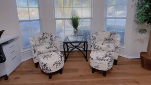 A room with two floral-patterned chairs, a glass-top table, and a potted plant. - Cozy Corner Near I-20 & 360, Heart of DFW, Quiet Cul-de-Sac Stay (Arlington)