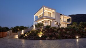 A modern two-story house with a flat roof, large windows, and a stone foundation. - Villa Elounda Lion, 2 Pools, Hammam & Close to Sea (Agios Nikolaos)