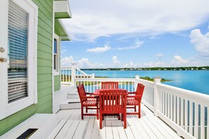 A wooden deck with a table and chairs, overlooking a body of water. - Waterfront | Pet-Friendly | Private Pool, Boat Launch Access (Gulf Shores)