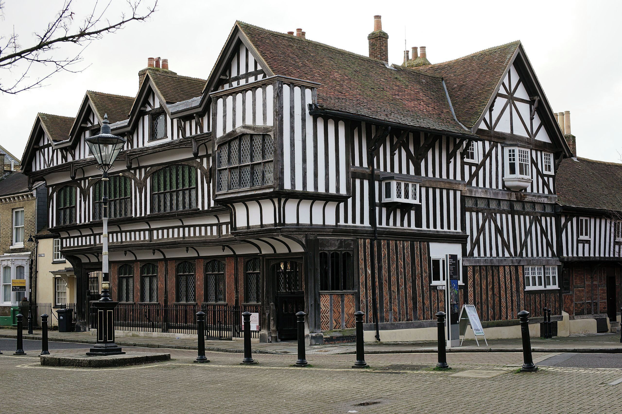 A traditional half-timbered building with a covered front porch and multiple windows.
