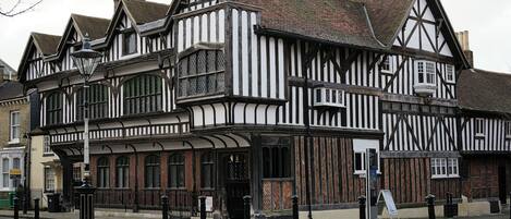 A traditional half-timbered building with a covered front porch and multiple windows.