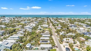 A coastal residential area with houses, palm trees, and a clear view of the ocean. - Jersey Gal 3 Bedroom Home (Anna Maria)
