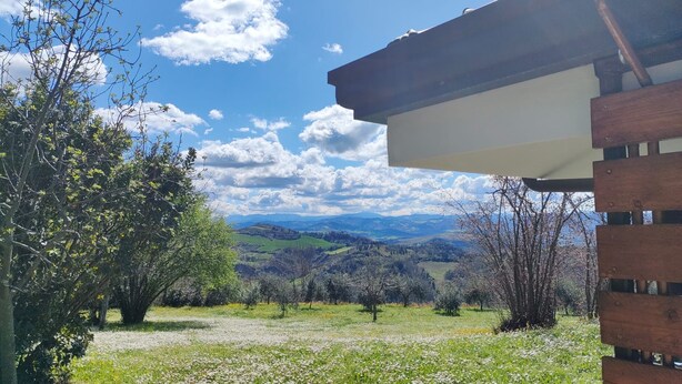 A view from a wooden building with a clear sky and distant mountains. - VILLA CUBETTO, an oasis of relaxation in the hills of Romagna (Emilia-Romagna)