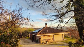 A small, single-story house with a sloped roof, solar panels, and a chimney. - VILLA CUBETTO, an oasis of relaxation in the hills of Romagna (Emilia-Romagna)