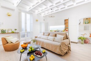 Una sala luminosa con sofá, mesa de centro y comedor.