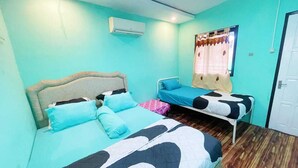 Una habitación con dos camas, una ventana con cortinas, un equipo de aire acondicionado y una puerta.