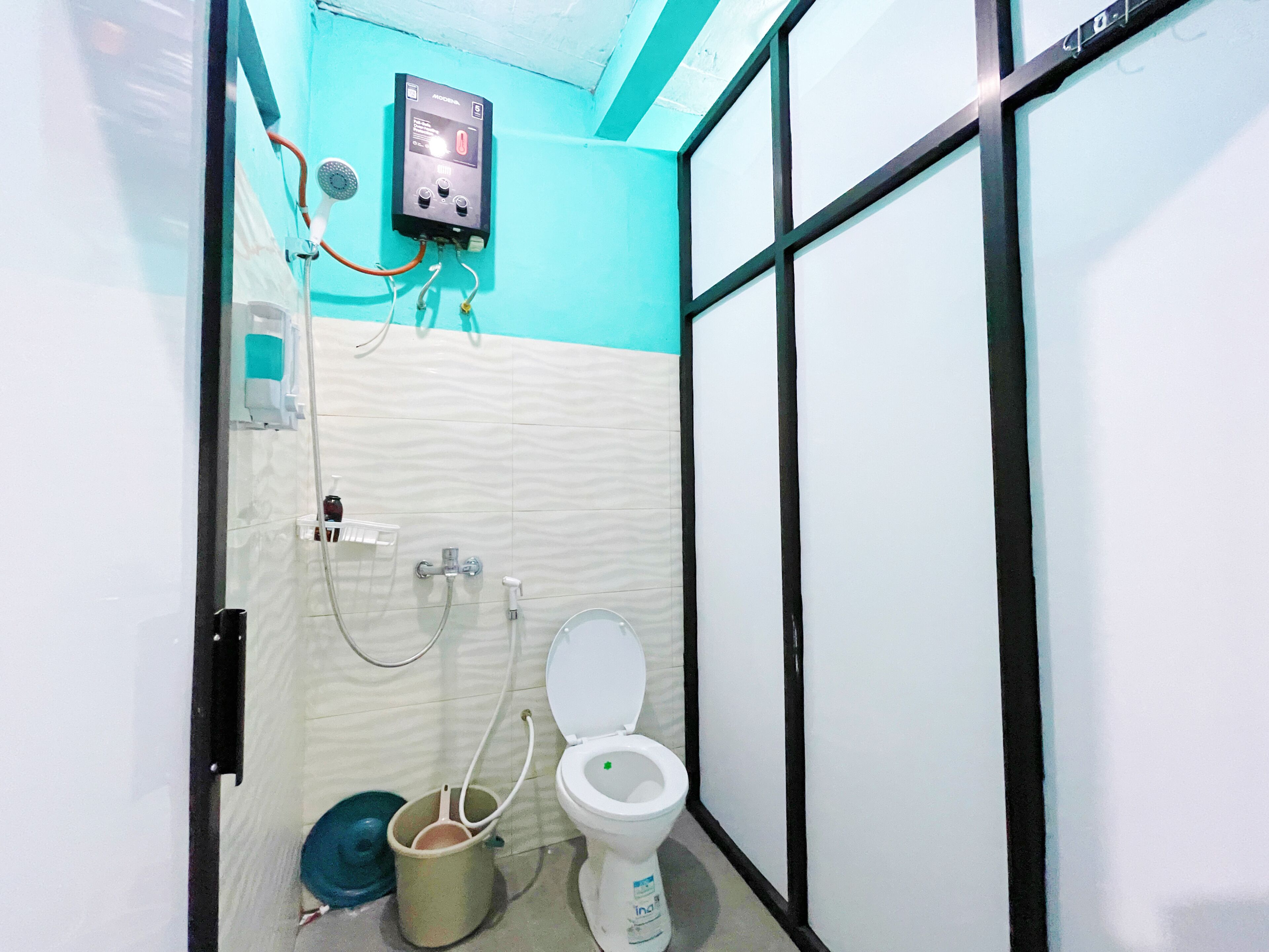 A small bathroom with a toilet, a bidet, and a water heater mounted on the wall.