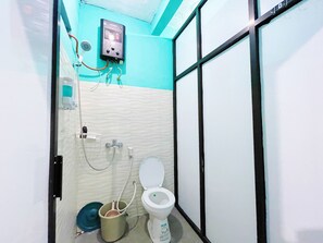 A small bathroom with a toilet, a bidet, and a water heater mounted on the wall. - Bronk House 2 Tamsis (Yogyakarta)