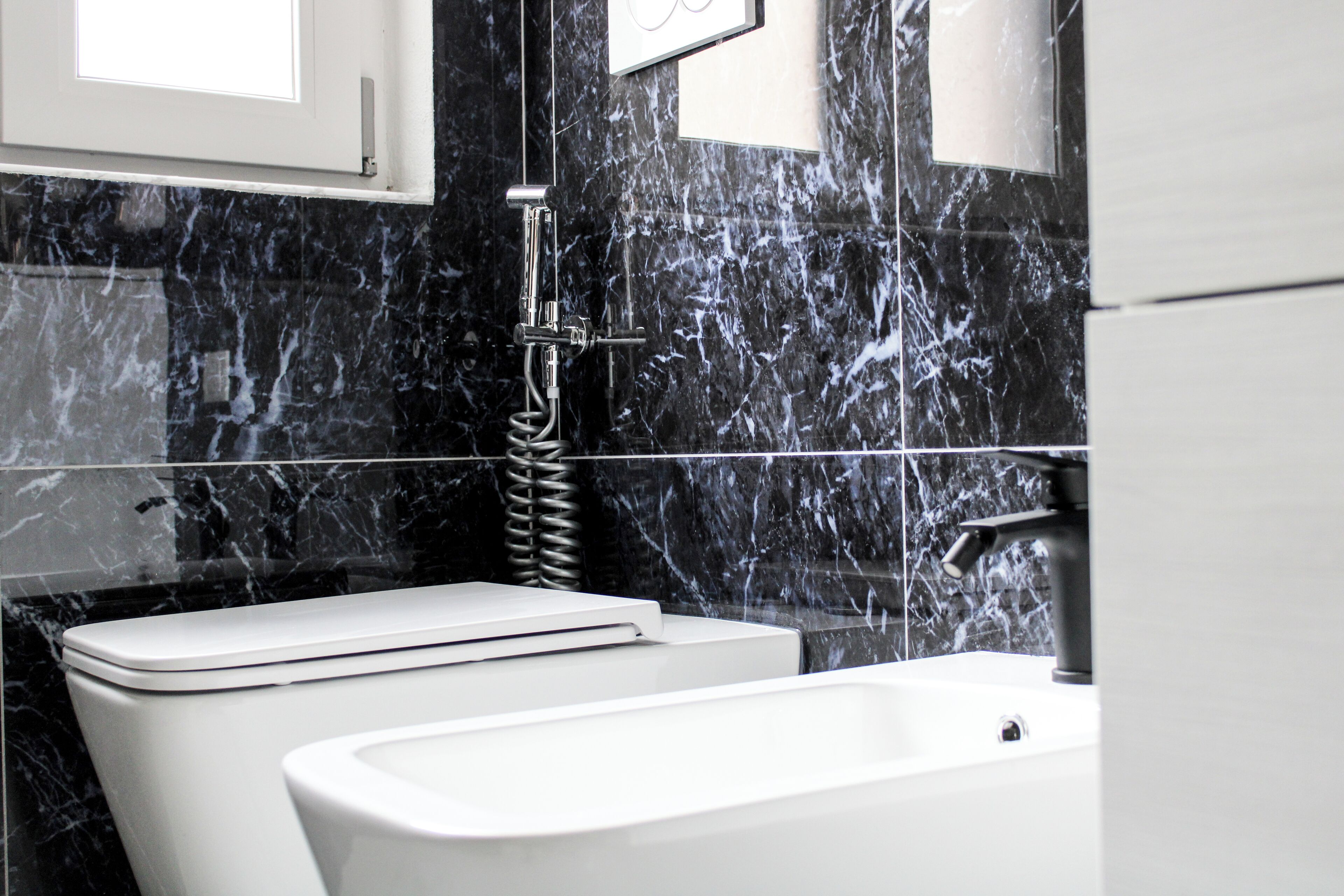 Une salle de bain moderne équipée de toilettes, d’une baignoire et d’une douche.
