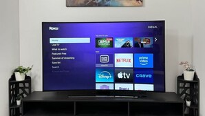 Un televisor de pantalla plana montado en la pared, con un mueble de entretenimiento moderno debajo.