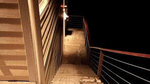 Eine Treppe mit Metallgeländer, die in einen dunklen Bereich führt.