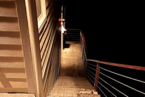 Una escala amb barana metàl·lica que condueix a una zona fosca més enllà.