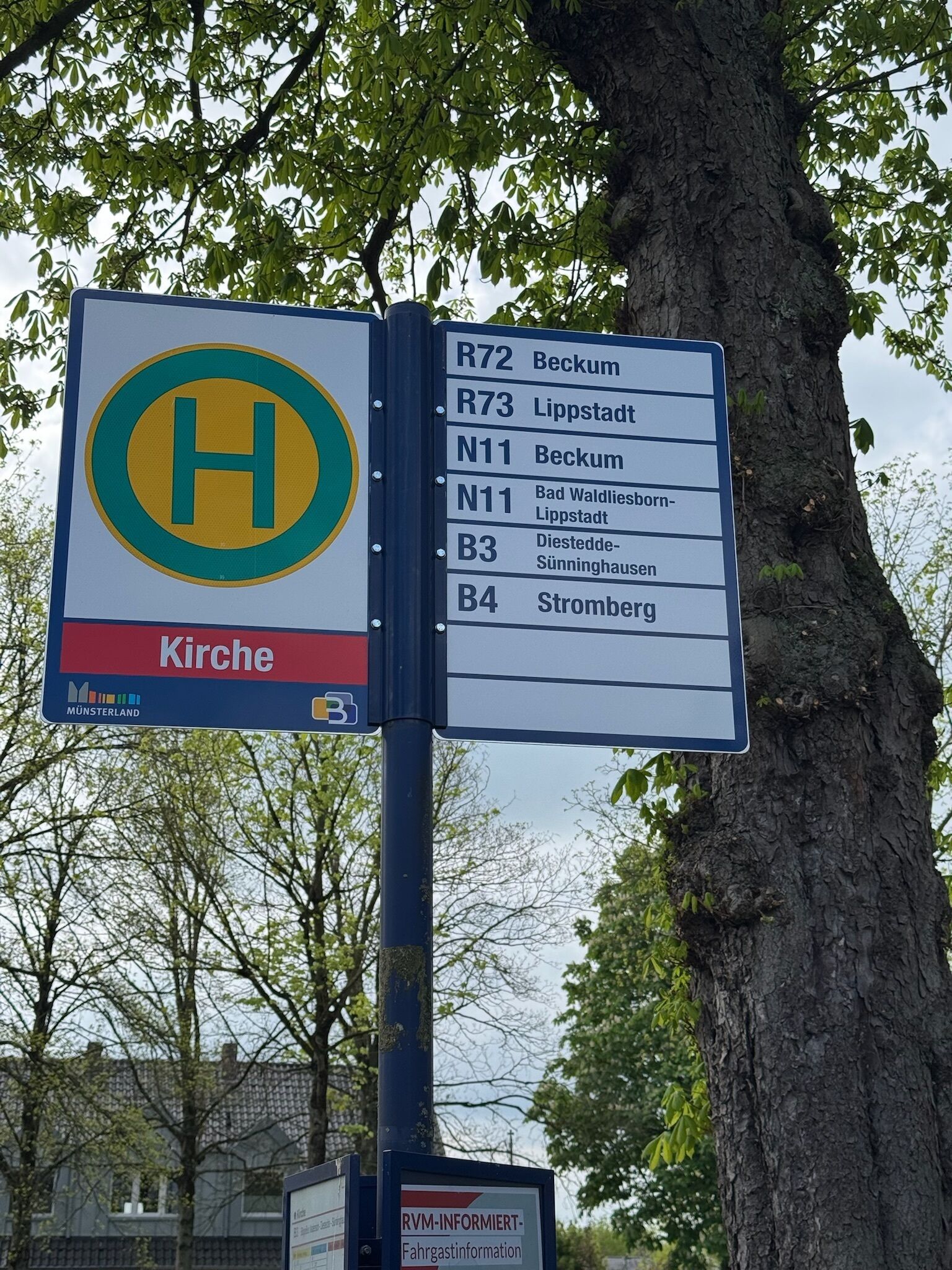 A directional sign with multiple route options and a symbol indicating a hospital.