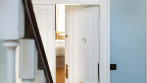 A staircase leading to a room with a white door and a nameplate.