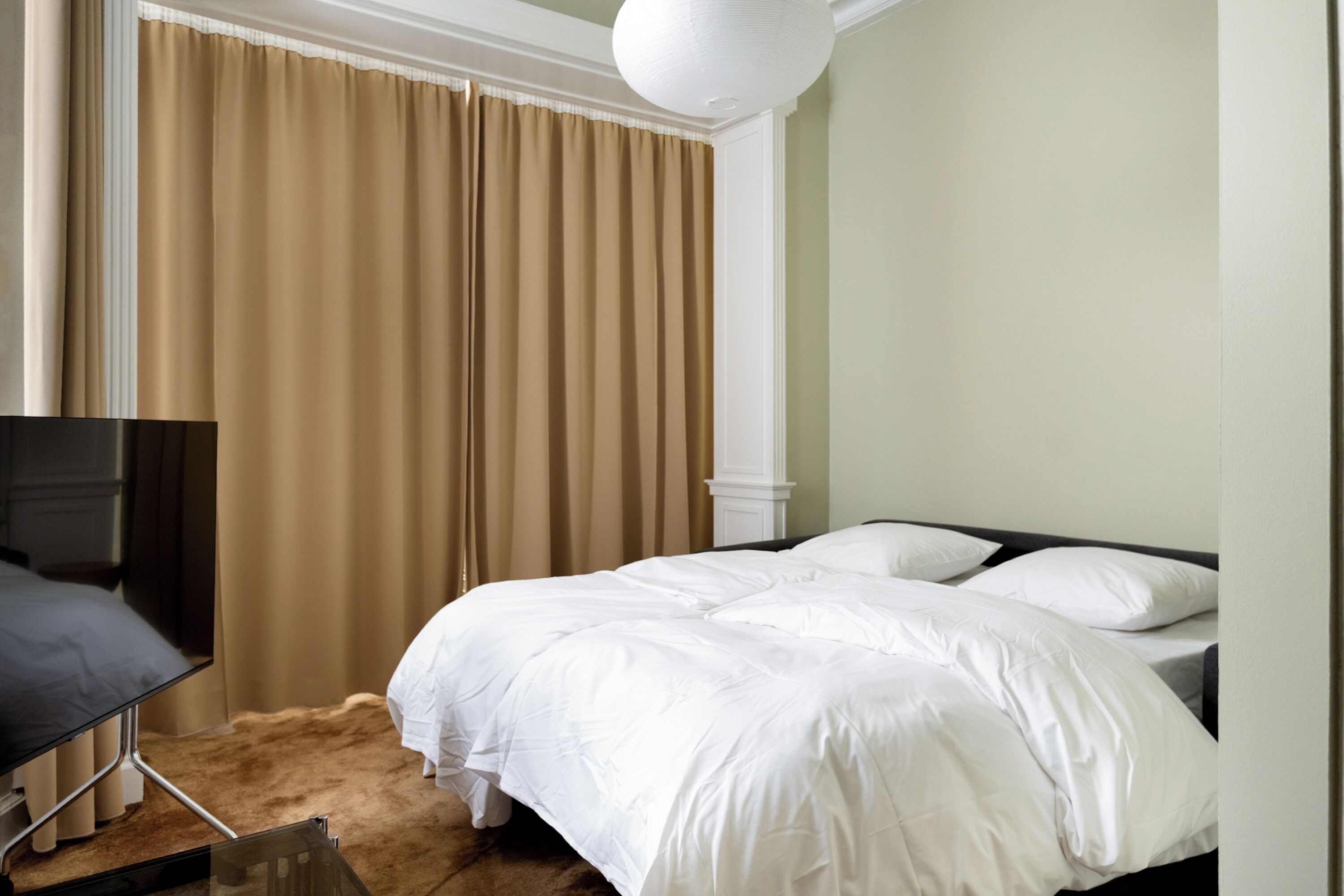 Une chambre d’hôtel avec un lit, un bureau et une télévision.