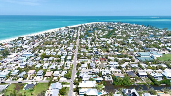 A coastal residential area with houses, roads, and a beach.