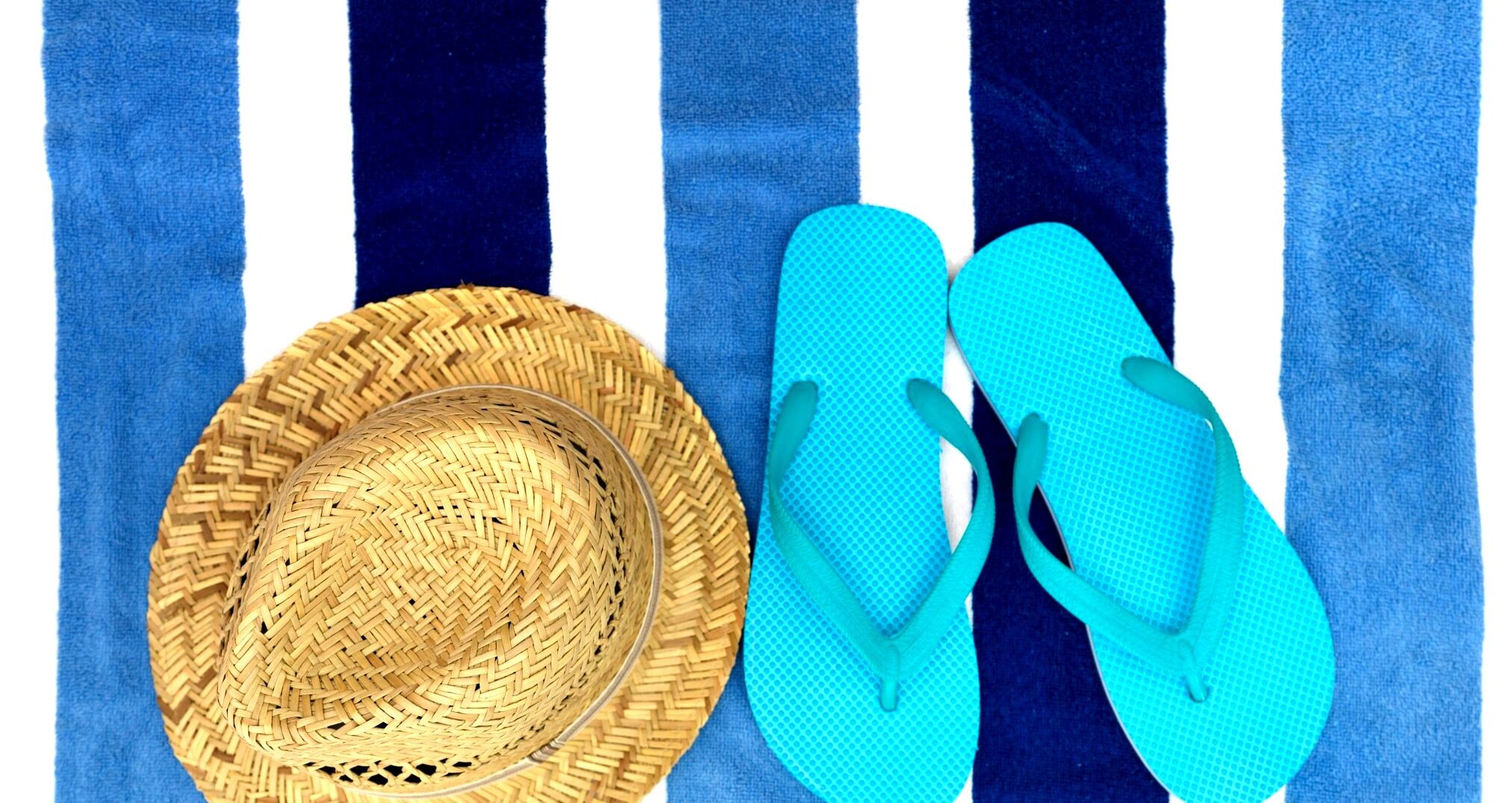 Een stroohoed en blauwe slippers op een gestreepte achtergrond.