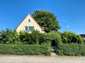 Une maison avec un toit rouge, une antenne parabolique et une petite fenêtre.