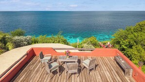 A wooden deck with outdoor seating and a view of the ocean. - Villa La Brisa with a tropical garden, private pool and spectacular views (Kralendijk)