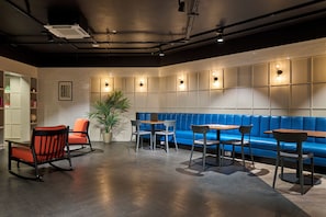 A modern lounge area with seating arrangements, including sofas and chairs, and a potted plant. - For Students Only - Studio Rooms in Reading (Reading)