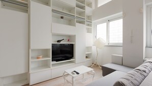 A modern living room with a TV, white furniture, and a window. - GuestHost - Milan Cosy Studio on 2 levels! (Milano)