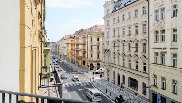 Una vista di strada con edifici, auto e un attraversamento pedonale.