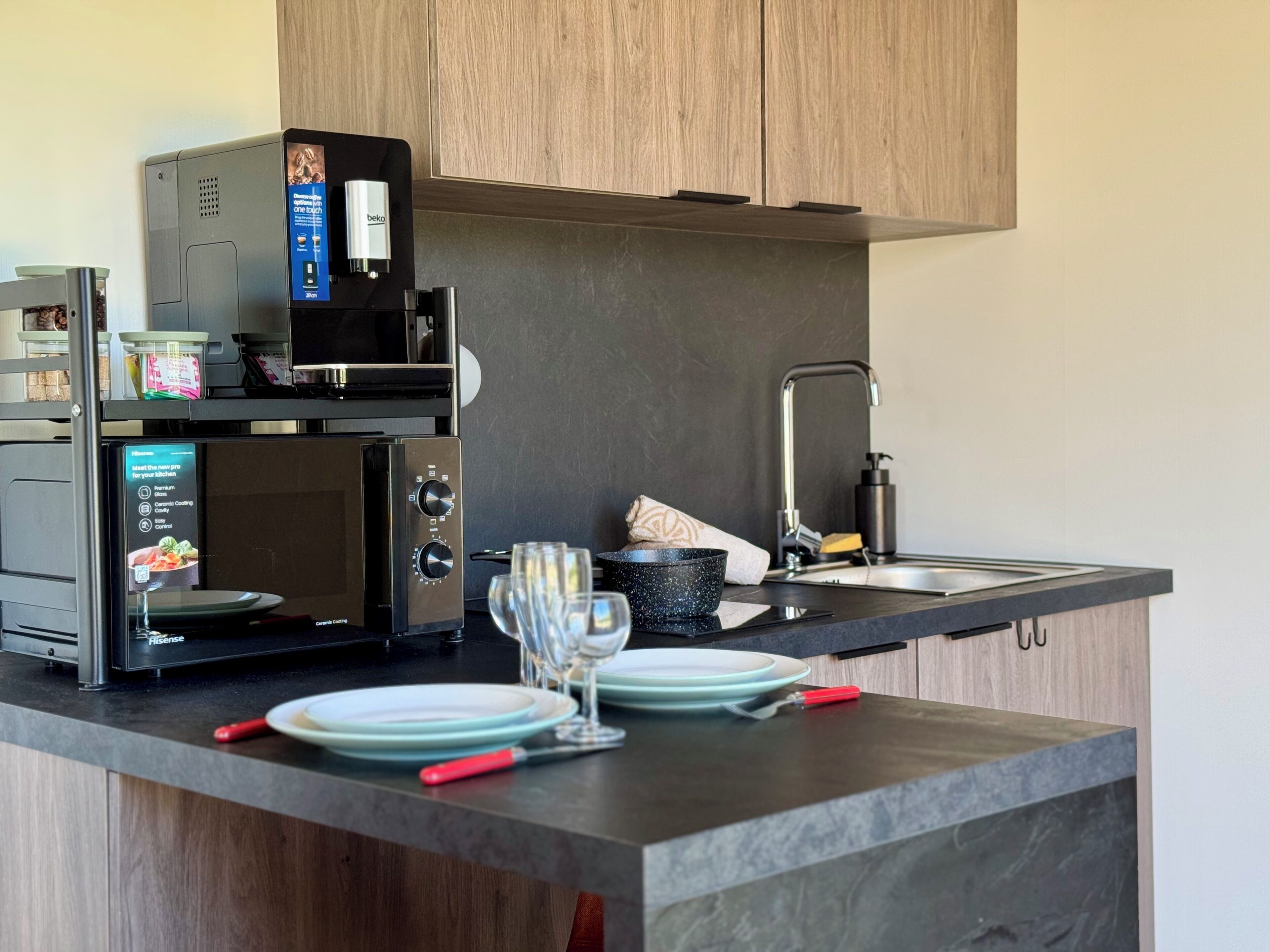Uma cozinha moderna com micro-ondas embutido, máquina de café e pia.