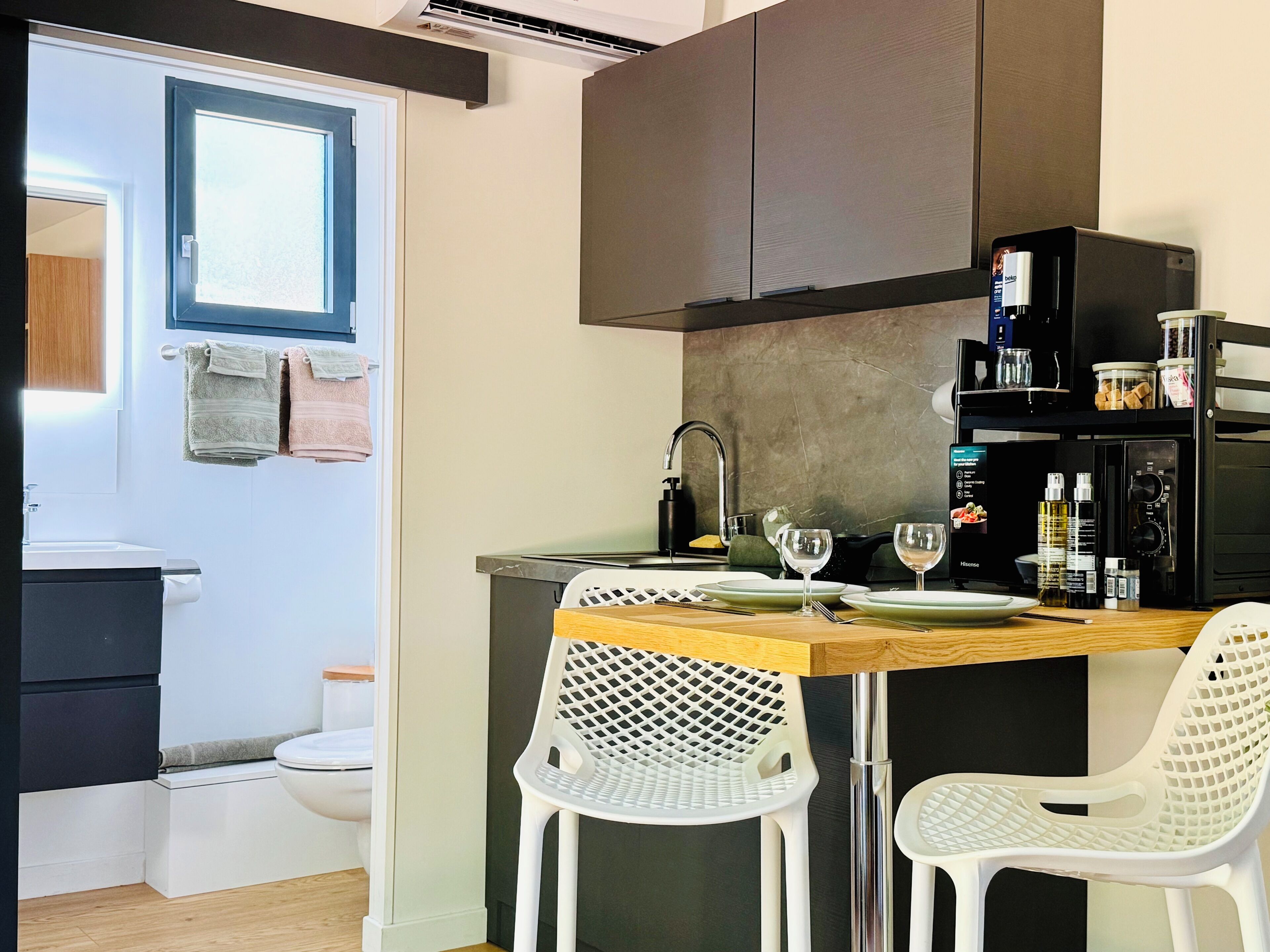 A compact kitchen with a dining area, a built-in microwave, and a small refrigerator.