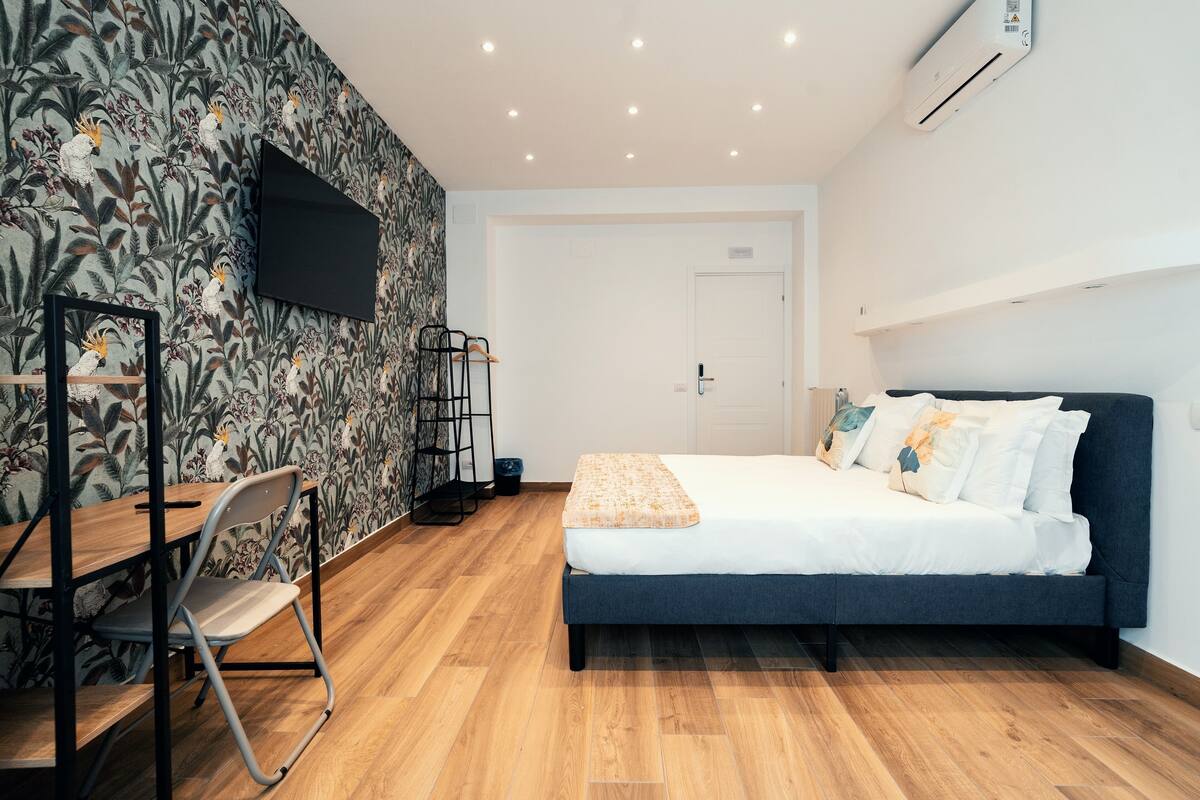 Un dormitorio moderno con una cama, un escritorio y una silla.