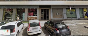 A parking lot with three cars parked in front of a building with a 'PIZZIUM' sign. - Casa Mia SanPietro (Rome)