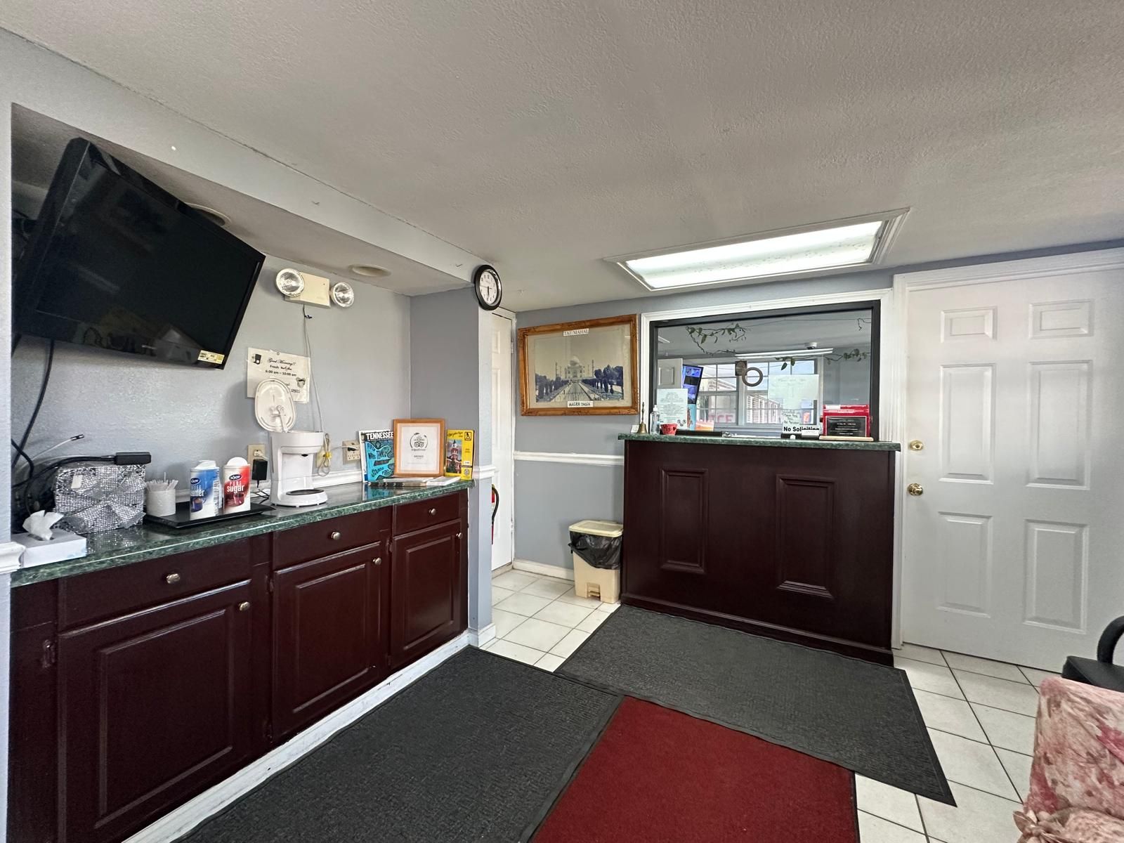 Une cuisine équipée d’un four à micro-ondes, d’une machine à café et de divers ustensiles de cuisine disposés sur le plan de travail.