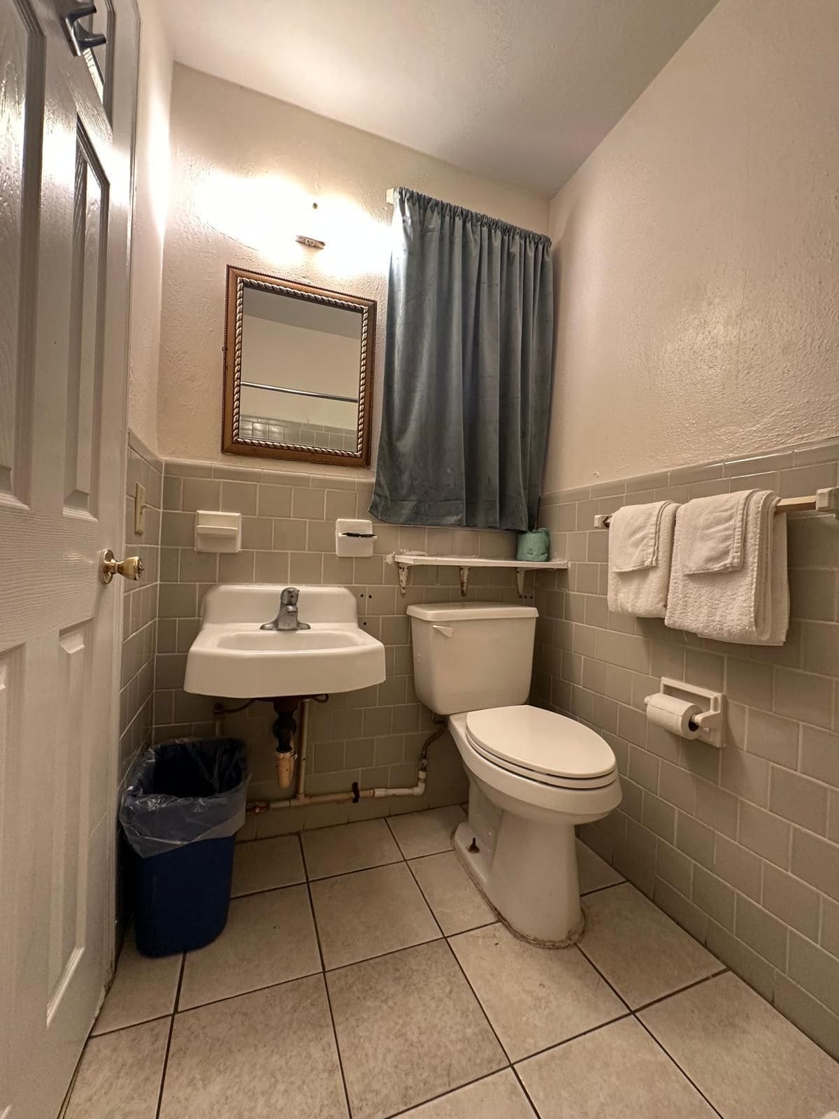 Un bagno con il water, lavandino e specchio.