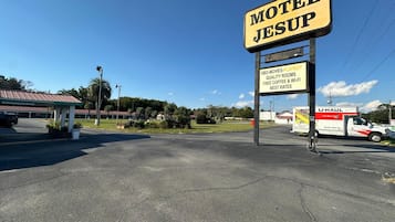 A motel named 'Motel Jesusup' with a signboard advertising HBO movies, playboy, quality rooms, free coffee, Wi-Fi, and best rates.