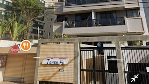 Un edificio de varios pisos con un diseño arquitectónico moderno, que cuenta con balcones y ventanas amplias.