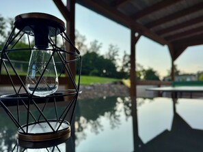A glass lantern on a reflective surface with a clear view of a park and a building in the background. - Family-friendly, spacious vacation apartment in a quiet, rural location (Bliesdorf)