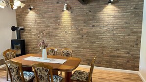 Ein Essbereich mit Backsteinwand, Holztisch und Stühlen.