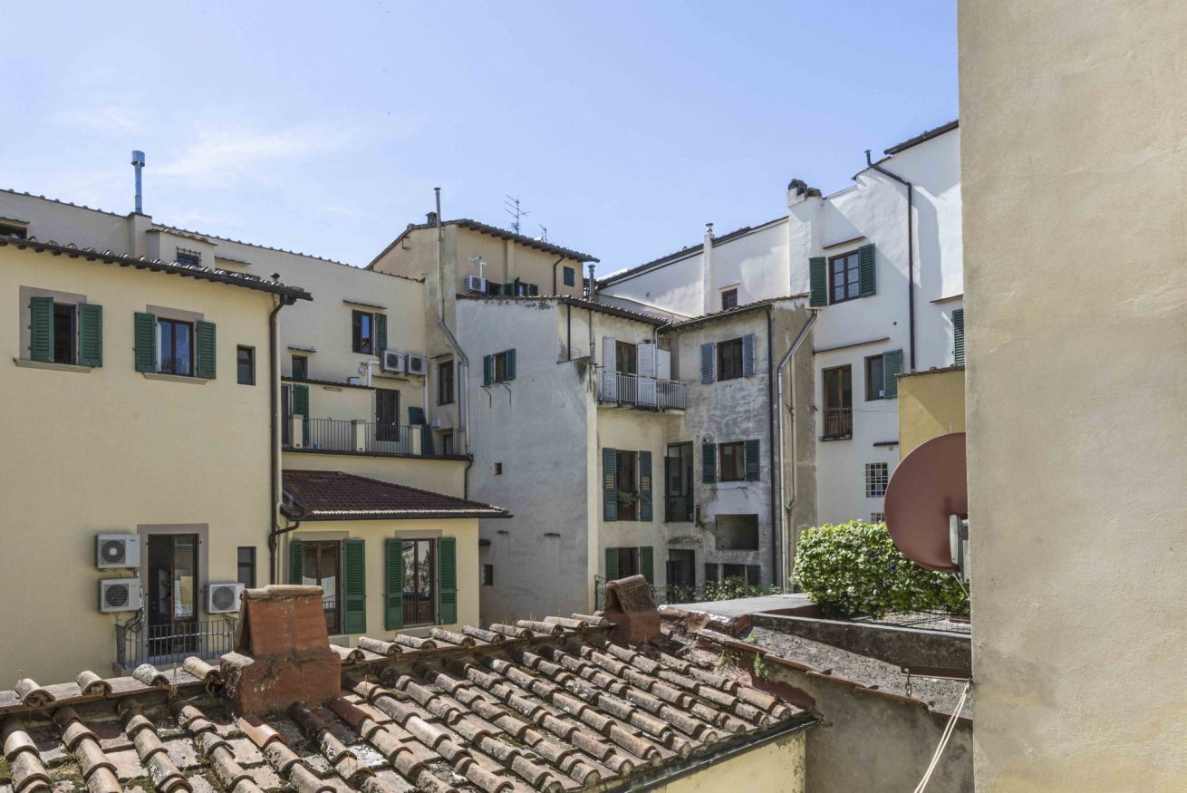 Eine schmale Straße mit Gebäuden, die Balkone und Satellitenschüsseln haben.