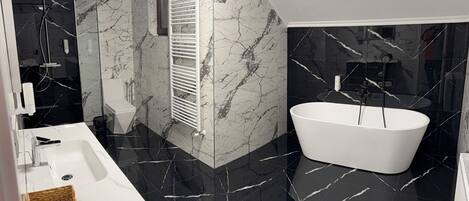 Un baño moderno con una bañera blanca, un lavabo y una zona de ducha.