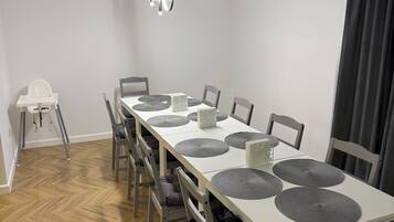 Un comedor con una mesa larga, varias sillas y una lámpara en el techo.