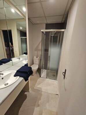 Een douche, handdoeken, toiletpapier