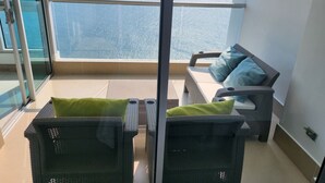 Un balcone con mobili in vimini e vista mare.