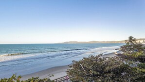 A beach with waves, a clear sky, and distant hills. - Beachfront Apartment With Beach View Vte0301 (Itapema)
