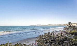 A beach with waves, a clear sky, and distant hills. - Beachfront Apartment With Beach View Vte0301 (Itapema)